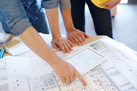 Bauen mit Mammen Bauleiter beraten sich über einem Bauplan